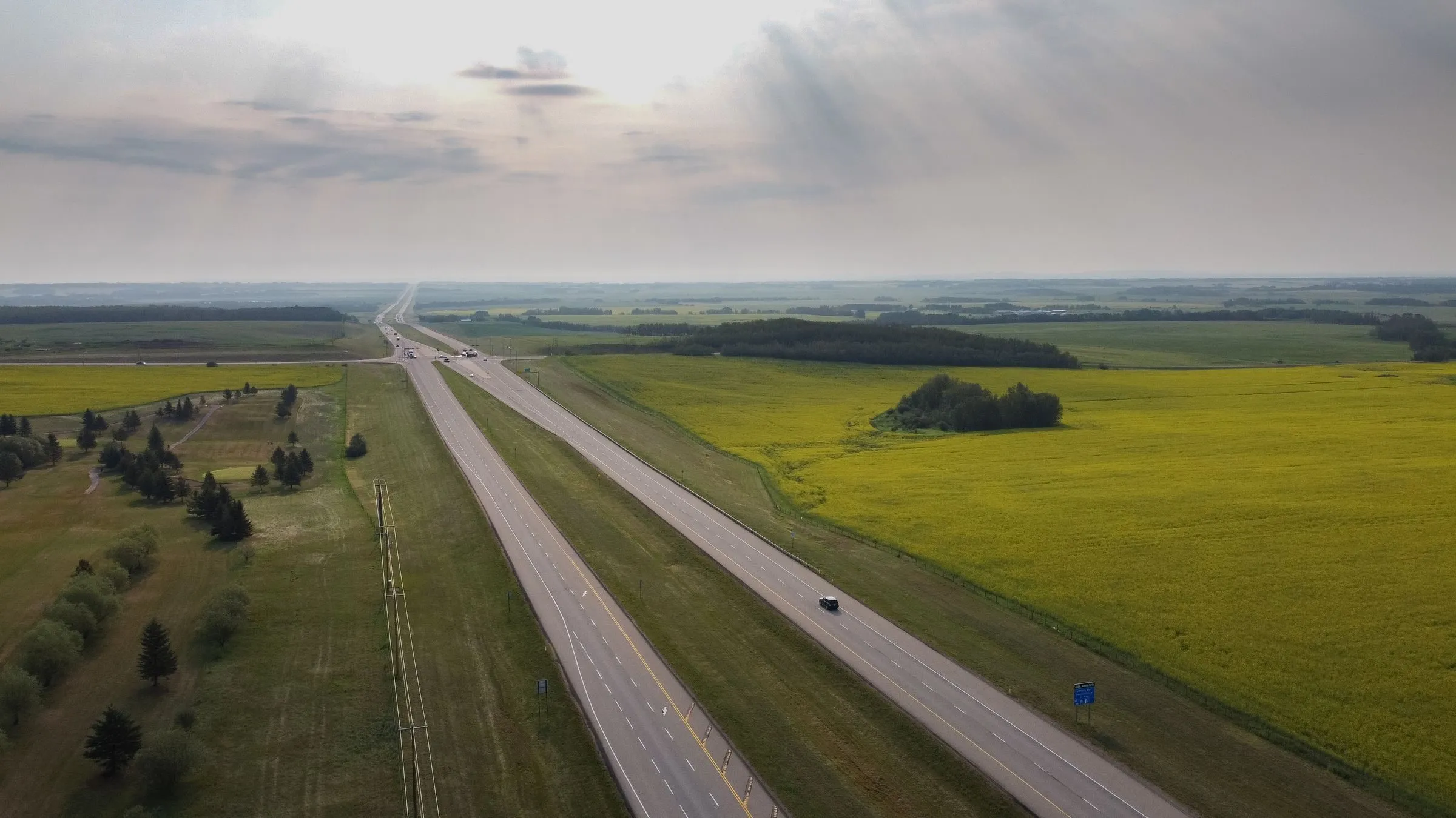 Aerial view of a highway through green farmland near Sylvan Lake, Alberta