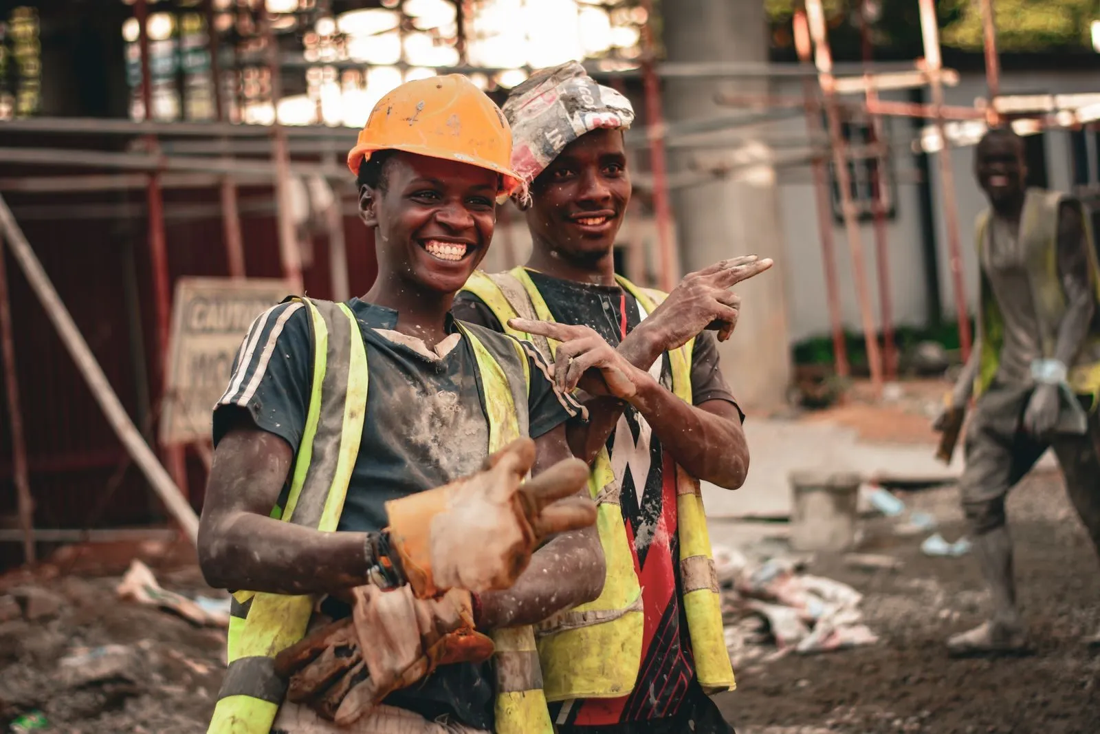 A construction crew in hard hats smiling on site