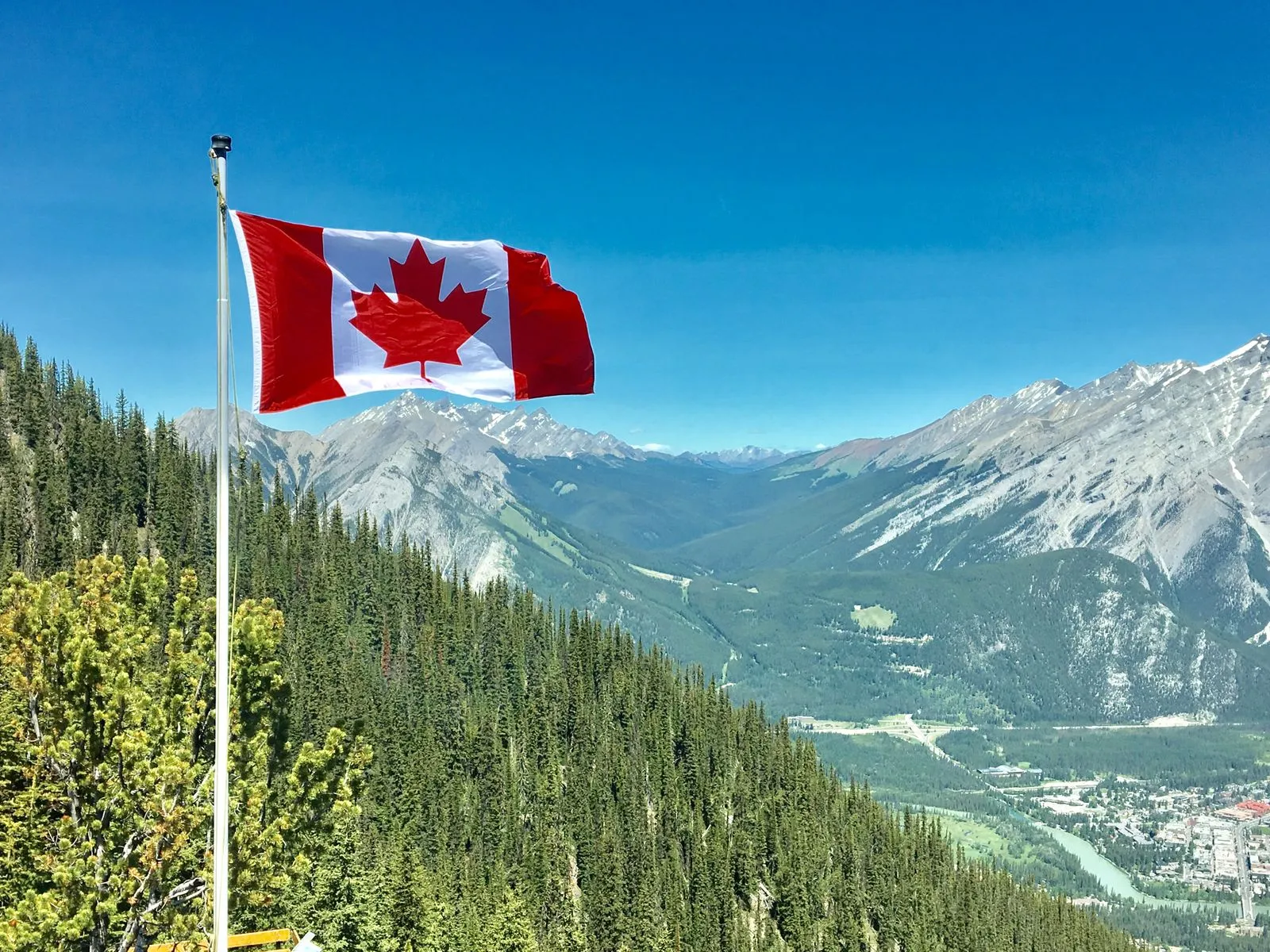 A Canadian flag flying over the Rocky Mountains near Banff