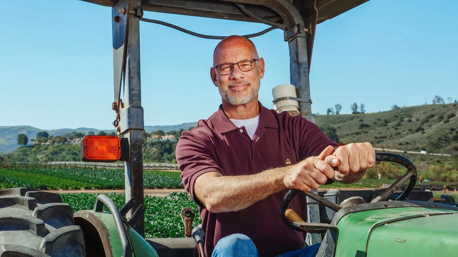 A farmer smiling on his tractor