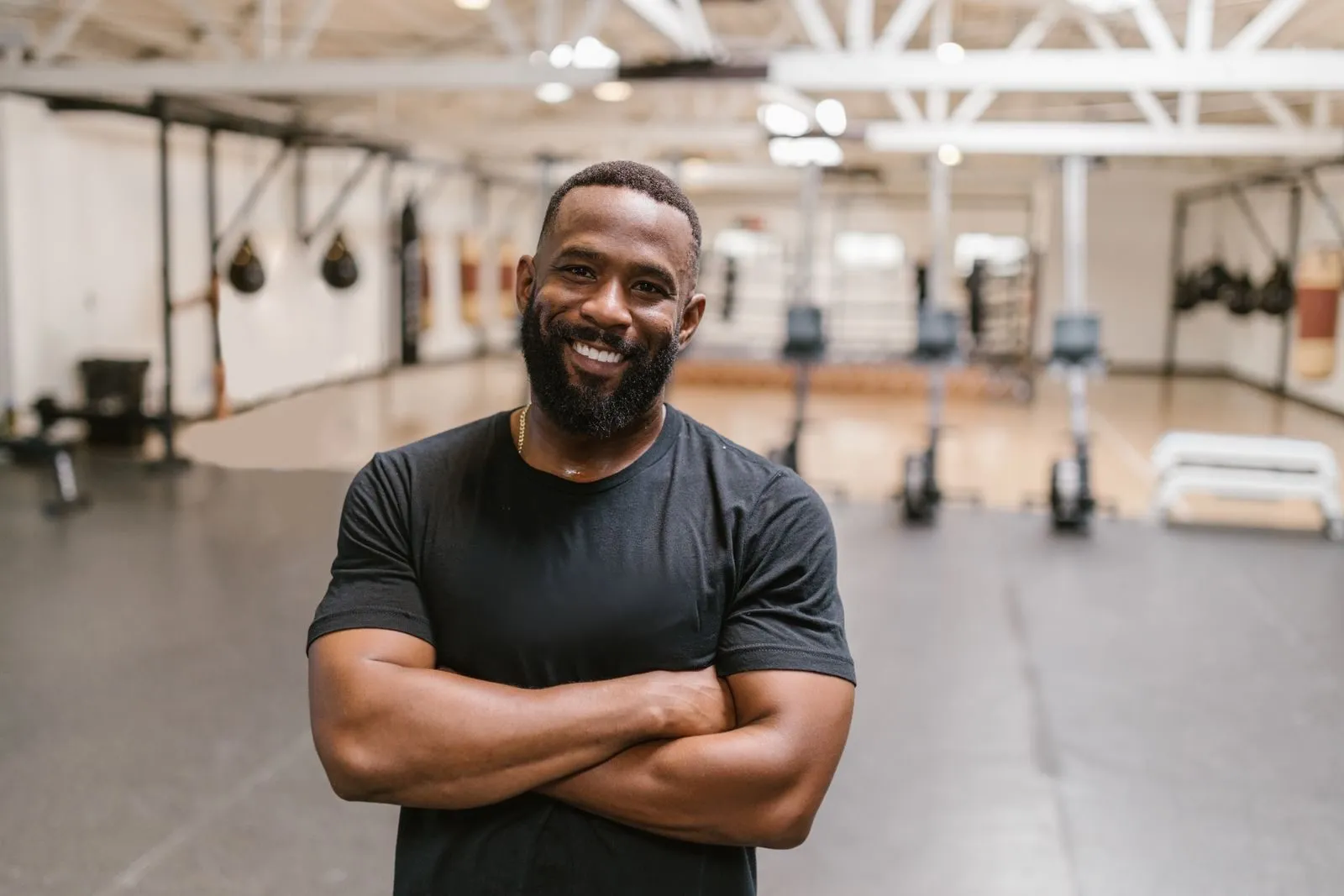 A gym owner smiling on his training floor