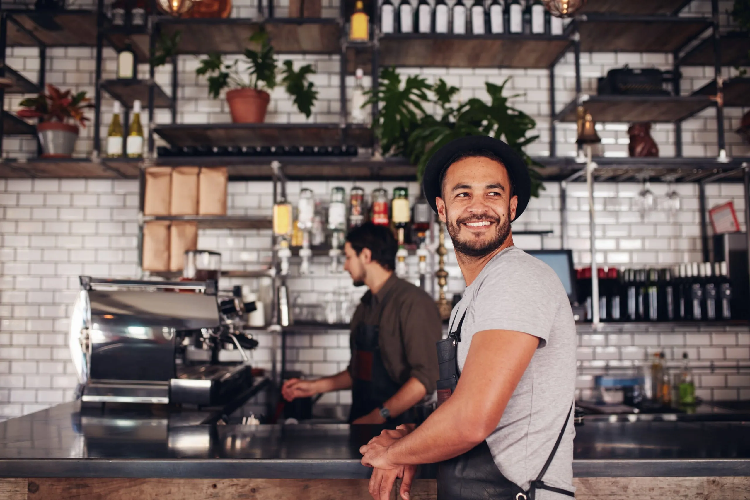 A smiling café owner behind his counter